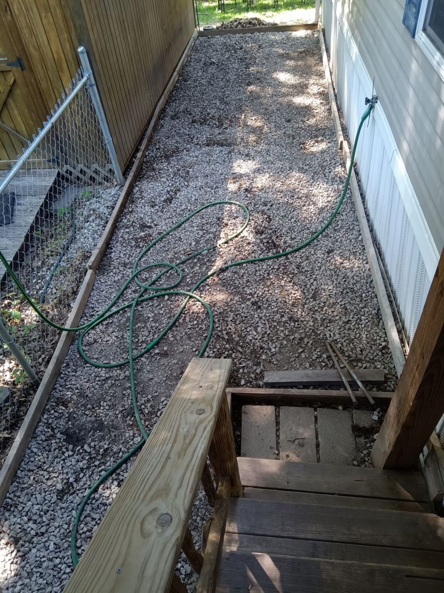 Before — Side yard prepped with base rock and forms before the concrete pour