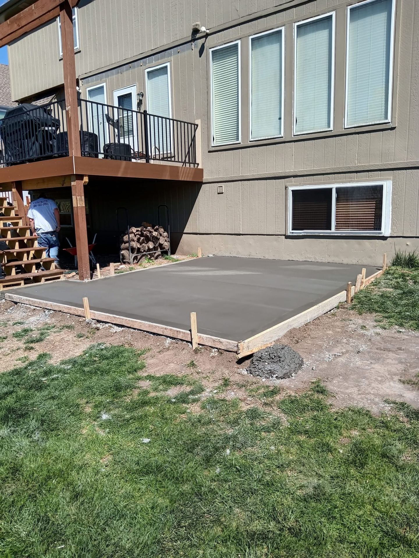 Concrete slab poured under a wooden deck staircase