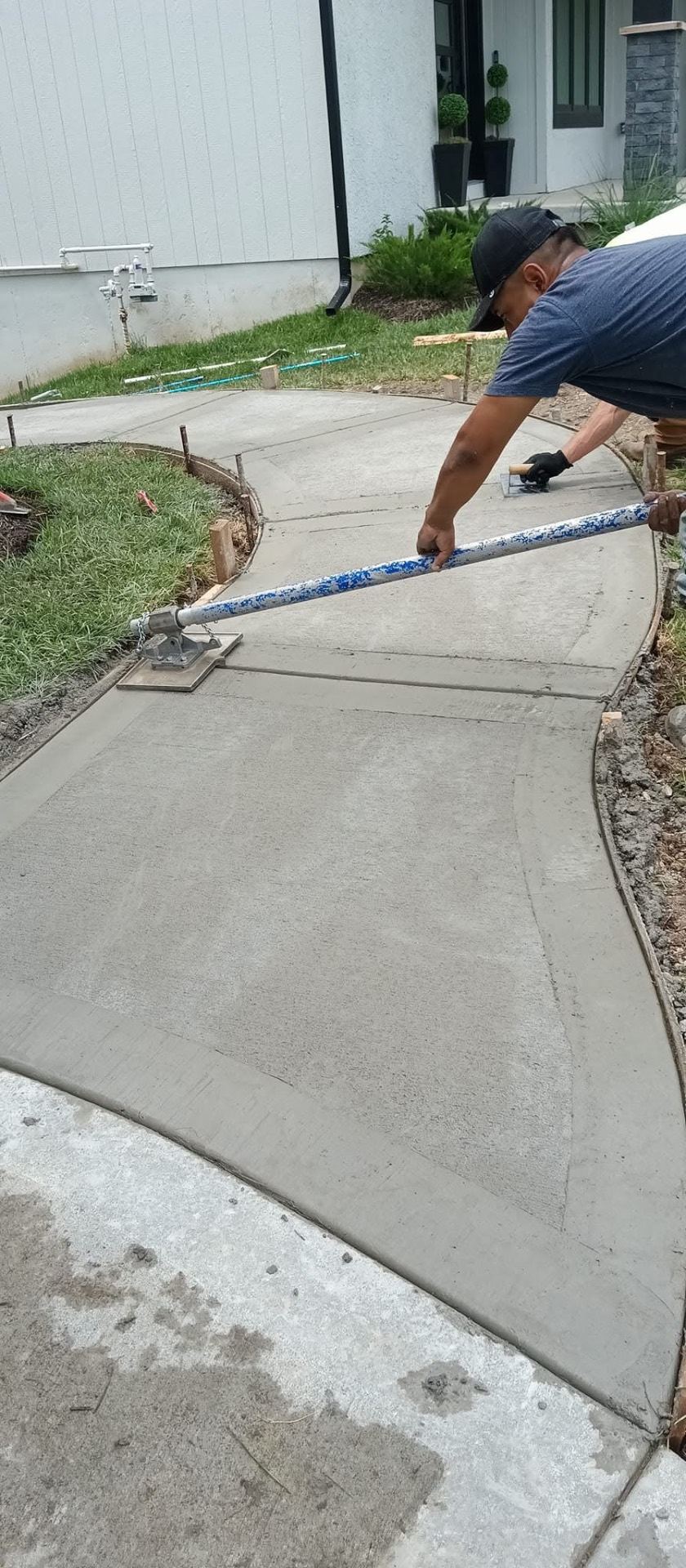 J C Concrete Flatwork crew member finishing a curved concrete walkway